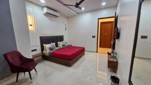 a bedroom with a red bed and a chair at New Kanha Hotel in Jaipur +1 photo