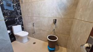 a bathroom with a toilet and a phone on the wall at New Kanha Hotel in Jaipur