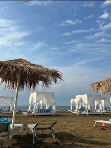 バクーにあるSea Breeze, Polo Residence, Bakuのビーチのパラソルと椅子