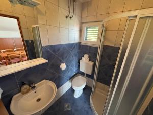 ein Badezimmer mit Waschbecken, Toilette und Dusche in der Unterkunft Rose Wind Apartments by Pag tours in Pag + 48 Fotos