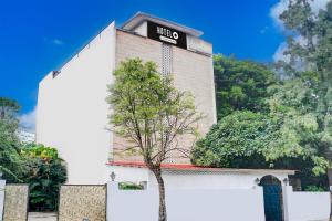 a building with a tree in front of it at Super Hotel O Bopodi Near Pune IT Park in Pune +49 photos