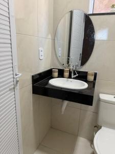 a bathroom with a sink and a mirror at Residencial Portela 08C in Fortaleza