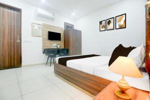 a bedroom with a bed and a desk with a chair at Super Collection O Sherpur Road Near Mohan Dai Oswal Hospital in Ludhiana
