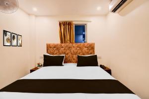 a bedroom with a large white bed and a window at Super Townhouse Civil Lines Prayagraj Formerly Raj Mahal Palace in Civil Lines