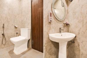 a bathroom with a sink and a toilet and a mirror at OYO Townhouse Civil Lines Prayagraj Formerly Raj Mahal Palace in Civil Lines +46 photos