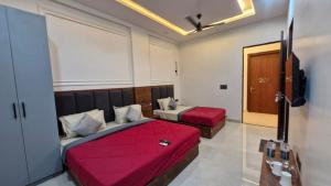 a hotel room with two beds and a television at New Kanha Hotel in Jaipur