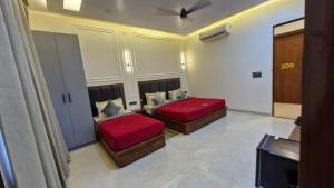 a room with two beds and a tv in it at New Kanha Hotel in Jaipur