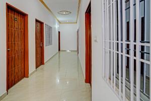 an empty hallway with wooden doors and a hallwayngth at Hotel O RR Palace in Bheta +37 photos