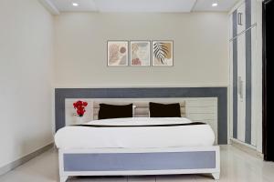 a bedroom with a large bed and two paintings on the wall at Super Collection O Sector 70 Noida in Noida
