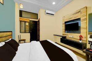 a bedroom with a bed and a flat screen tv at Super Collection O ISKCON Radha Govind Formerly Hotel Shivom in Indore