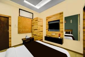 a bedroom with a large bed and a television at Super Collection O ISKCON Radha Govind Formerly Hotel Shivom in Indore