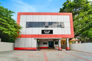a white and red building with a sign on it at Super Hotel O Kanyakumari Near Sunrise View formerly Jaisas Paradise in Kanyakumari +27 photos