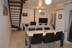 a living room with a table and chairs and a television at maison 3 classée étoiles à,proximité de Contis Plage in Saint-Julien-en-Born