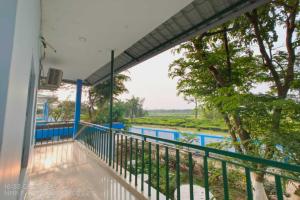 balcón con vistas al río y a los árboles en Banobitan Resort, en Lataguri 3 fotos más