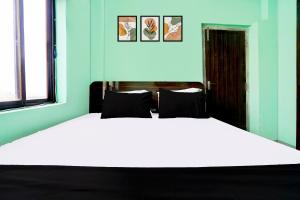 a bedroom with a white bed and two windows at Super Hotel O Bhagwanpur Chowk Muzaffarpur in Muzaffarpur +22 photos