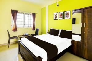 a bedroom with a large bed and a desk at Super Collection O Nibav Beach View in Chennai