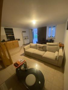 a living room with a couch and a table at Charmante Maison dans village calme in Chef-Boutonne