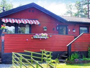 a red house with a red wall and a porch at 6 person holiday home in Lidköping in Lidköping