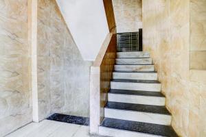 a staircase in a house with a stone wall at Hotel O Ambedkar Chowk Ulhasnagar in Kalyan