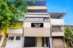 a tall white building with a hotel sign on it at Hotel O Ambedkar Chowk Ulhasnagar in Kalyan