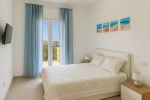 a white bedroom with a bed and a window at Home & Garden in Vico Equense