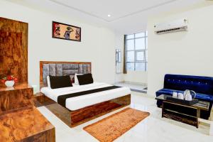 a bedroom with a large bed and a blue couch at Townhouse Narholi Bridge Mathura in Mathura