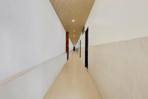 a long hallway with white walls and a ceiling at Super OYO Hotel O Machilipatnam in Machilīpatnam