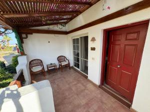 a porch with a red door and a table and chairs at Herrmes in Sharm El Sheikh