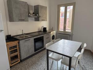 a kitchen with a table and a sink and a table and chairs at La Casa A Roseto in Roseto degli Abruzzi