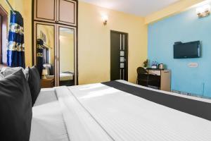 a hotel room with a bed and a tv at Super Hotel O Alipore Near Chetla Formerly Alipore Guest House in Kolkata