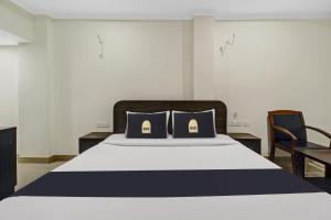 a bedroom with a large bed with two blue pillows at Super Townhouse Oak LB Nagar Ramoji in Hyderabad