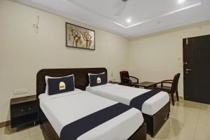 a bedroom with two beds and a table and chairs at Super Townhouse Oak LB Nagar Ramoji in Hyderabad