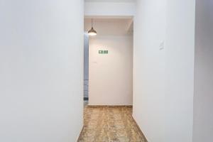 an empty hallway with white walls and wood floors at Super Hotel O Dhanori Near Pune Airport in Pune