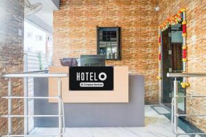 a hotel counter in front of a brick wall at Super Hotel O Dhanori Near Pune Airport in Pune