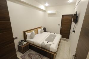 a bedroom with a bed with a laptop on it at Hotel Pearl Square in Jaipur +11 photos