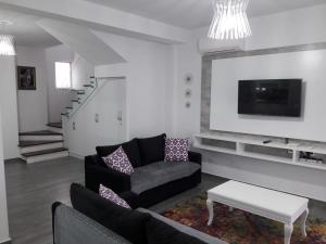 a living room with a couch and a tv at Super Leisure Vila-Plazhi San Pietro, Gjiri i Lalezit in Lalzit Bay