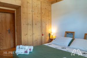 a bedroom with a bed and wooden walls at Dimora del Corso Cortina in Cortina dʼAmpezzo
