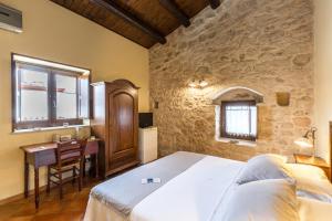 Een bed of bedden in een kamer bij La Muraglia Residenza Turistica Rurale