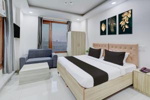 a bedroom with a bed and a chair at Super Townhouse Sector 135 Noida in Noida