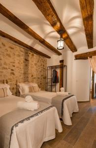 Linares de MoraにあるCasa Masoveraのベッドルーム(白いシーツが備わるベッド3台付)