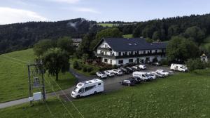 a group of cars parked in a parking lot in front of a house at Gasthaus Schöberingerhof in Weyregg