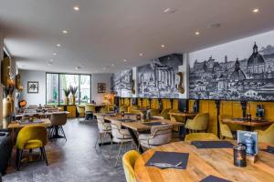 a restaurant with wooden tables and yellow chairs at Hotel restaurant de Pionier in Marknesse
