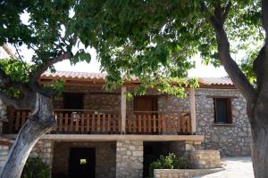 a stone house with a porch and a deck at Traditional Stone Guesthouse in Áyios Ioánnis +19 photos