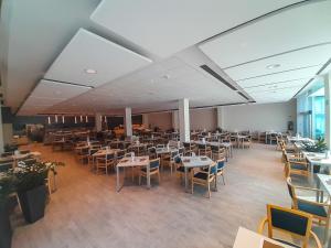 a restaurant with tables and chairs in a room at Hotel Zdravilisce - Thermana Lasko in Laško
