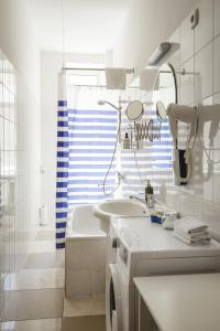 een badkamer met wastafel en wasmachine bij Bearsleys Archers Apartments in Rīga +77 foto's