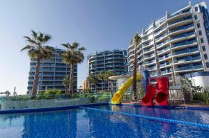 a swimming pool with a water slide in a resort at Sea Senses by Mar Holidays in Torrevieja