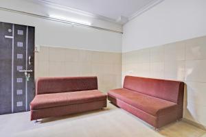 a waiting room with two red seats in a room at Super Hotel O Rane Nagar formerly Shree Mangal Complex in Nashik