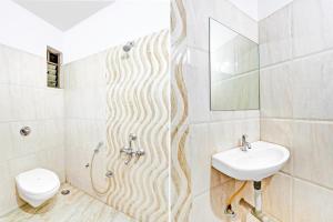 a bathroom with a sink and a toilet at Super Hotel O Rane Nagar formerly Shree Mangal Complex in Nashik