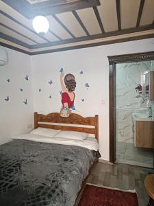ein Schlafzimmer mit einem Bett und einem Gemälde an der Wand in der Unterkunft Şirince Larin Pansiyon in Selçuk
