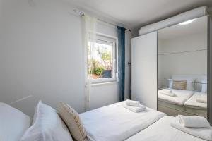 a bedroom with two beds and a mirror at Bayview Villa by Pag tours in Pag
